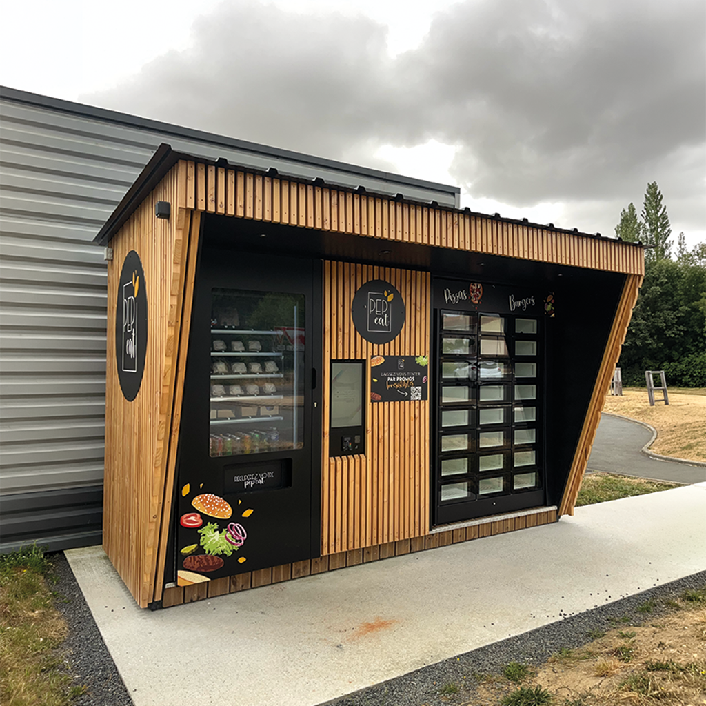 Distributeur automatique de burger dans une structure en bois et un distributeur de pizza